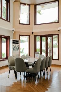 Zeus Living - Oasis Villa in Thao Dien في مدينة هوشي منه: غرفة طعام بها طاولة وكراسي ونوافذ