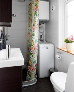 a bathroom with a toilet and a shower curtain at Backes Lillstuga in Borlänge