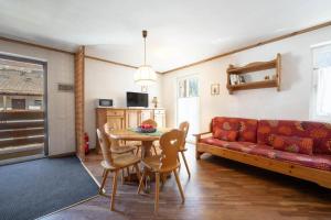 a living room with a red couch and a table at Residence Canazei in Alba di Canazei