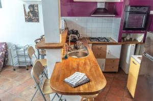 a kitchen with a wooden table and a sink at Maison de bourg Cébazat in Cébazat +1 photo