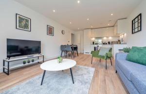 a living room with a couch and a table at Stylish 2BR Apartment at Trinity Point Gravesend in Gravesend