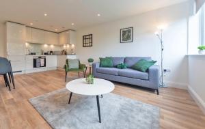 a living room with a couch and a table at Stylish 2BR Apartment at Trinity Point Gravesend in Gravesend
