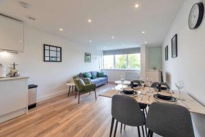 a dining room and living room with a table and chairs at Stylish 2BR Apartment at Trinity Point Gravesend in Gravesend