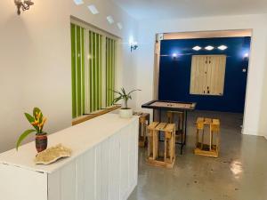 a room with a table and some stools in it at Berg house Hostel in Mirissa