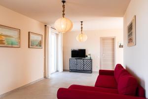 a living room with a red couch and a tv at Vigne Marrone B&B in Fossacesia