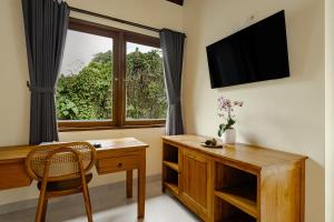 a home office with a desk and a window at Yanyan Resort Ubud in Ubud