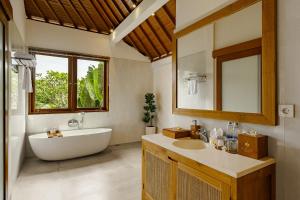a bathroom with a tub and a sink and a mirror at Yanyan Resort Ubud in Ubud +161 photos