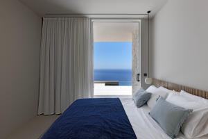 a bedroom with a bed with a view of the ocean at Celestia Cove, Earthy Architecture Meets Endless Blue by etouri 
