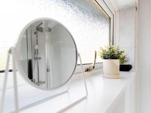 Un baño blanco con un espejo redondo sobre un mostrador. en Prime House, en Middlesbrough 33 fotos más