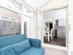 Una sala de estar con un sofá azul y una ventana grande. en Prime House, en Middlesbrough