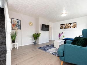 Una sala de estar con un sofá azul y un televisor. en Prime House, en Middlesbrough