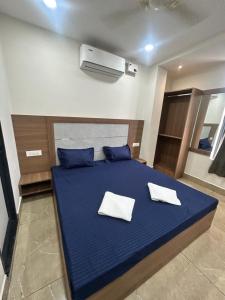 a bedroom with a blue bed with two white pillows at Hotel VK in Beās