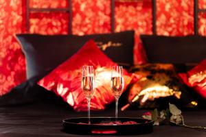 two champagne glasses on a table in front of a fireplace at Apartament Organza - Private Gym - Spa - Free Parking in Toruń