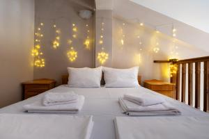 a bedroom with a white bed with lights on the wall at Villa Veselina Loft Studios in Hisarya