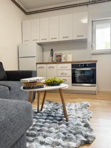 a living room with a table and a kitchen at Vele apartment in Mostar