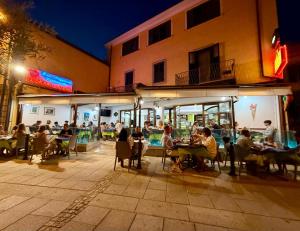 a group of people sitting at tables outside a restaurant at Il Giglio Affittacamere in Tortolì