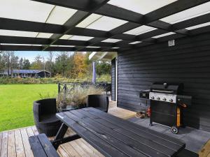 a patio with a picnic table and a stove at 5 star holiday home in Jerup in Jerup