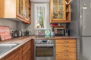 a kitchen with wooden cabinets and a stainless steel oven at Cosy Haven Apartment in Reykjavík