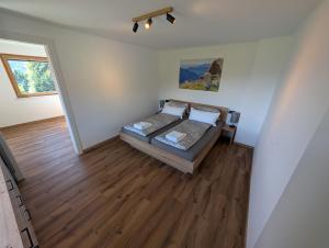 a bedroom with a bed and a wooden floor at Ferienwohnung am Bauernhof, Seeblick, Bergpanorama in Keuschen