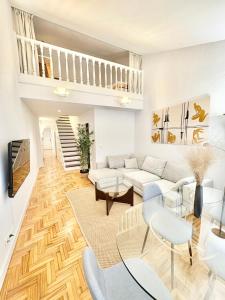 a living room with a couch and a table at Ático Duplex en el Corazón del Casco Histórico de Oviedo in Oviedo