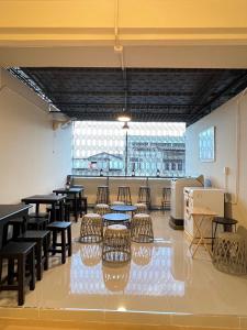 a room with tables and chairs and a large window at The Cage Suites in Bangkok