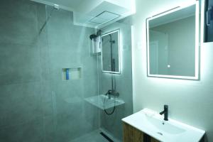 a bathroom with a sink and a shower with a mirror at Ski Vista house in Žabljak