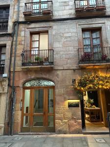 a brick building with a door and windows and flowers at Ático Duplex en el Corazón del Casco Histórico de Oviedo in Oviedo