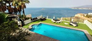 a swimming pool with a view of the ocean at Villa Hawai in Benidorm