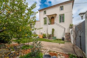 a large white house with a yard at Gîte indépendant l'Orchidée in Lespignan