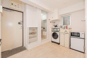 una cucina con lavatrice e asciugatrice in una stanza di Japan House Shirokane a Tokyo