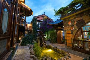 un jardín con un estanque en medio de un edificio en 丽江指云公馆Nakhi Cultural Experience在地体验民宿, en Lijiang