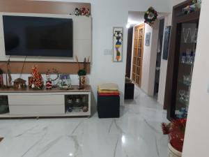 sala de estar con TV grande en la pared en TÔ em casa Barra Porto, en Salvador