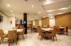 a restaurant with tables and chairs in a room at Hotel Almati Inn - Near Delhi Airport in New Delhi