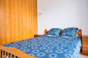 a bedroom with a bed with a blue comforter at Family house with beautiful garden in Saint-Hippolyte +6 photos