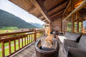un balcon avec des chaises et une vue sur les montagnes dans l'établissement Schöneben Chalet Anton, à Wald im Pinzgau