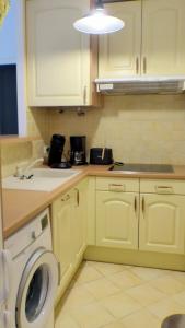 Apartment of 36 m2 with terrace في ساناري سور مير: مطبخ مع غسالة ملابس وغسالة ملابس