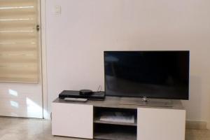 Apartment of 36 m2 with terrace في ساناري سور مير: تلفزيون بشاشة مسطحة جالس فوق مركز ترفيه ابيض