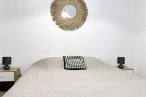 Apartment of 36 m2 with terrace في ساناري سور مير: غرفة نوم مع سرير ومرآة على الحائط +12 صورة