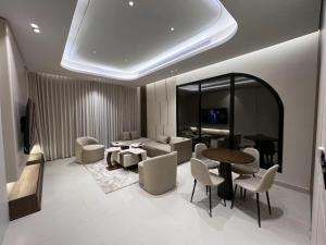 una sala de estar con un sofá, una mesa y sillas en Sadana, en Yeda