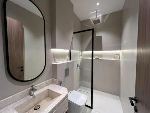 Un baño con lavabo, inodoro y espejo. en Sadana, en Yeda 66 fotos más