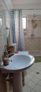 a white bathroom with a sink and a shower at Fole Maison in Durrës