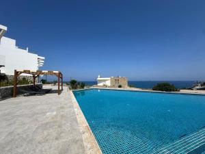 a swimming pool on the side of a villa at Azure Pearl Oceanfront Loft Apartment Spacious Rooftop Terrace Pool in Küçükerenköy