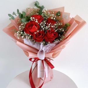 a bouquet of red roses in a pink at فندق سارة حسن in Riyadh