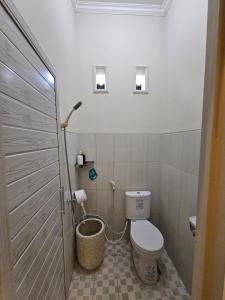 a small bathroom with a toilet in a room at Merapi Indah Hostel in Triwung