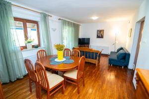 a living room with a wooden table and chairs at House Bianca with garden in Malinska