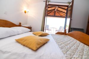 a bedroom with two beds with pillows and a window at House Bianca with garden in Malinska