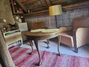 a room with a table and a chair and a lamp at Romantic countryside SAUNA Cottage in Maakeski +37 photos