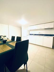 une pièce avec une table et des chaises et une cuisine dans l'établissement Logement Proche gare de Villiers le bel, 20 mins de Paris , Stade 2 France, Aéro CDG, Parc des expositions, Disneyland Paris,Futuroscope, Tour Eiffel, à Arnouville-lès-Gonesse 6 autres photos