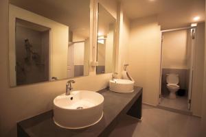 a bathroom with two sinks and a toilet at The Open House Cafe and Hostel in Bangkok