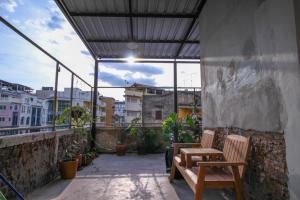 a balcony with two wooden chairs on a building at The Open House Cafe and Hostel in Bangkok